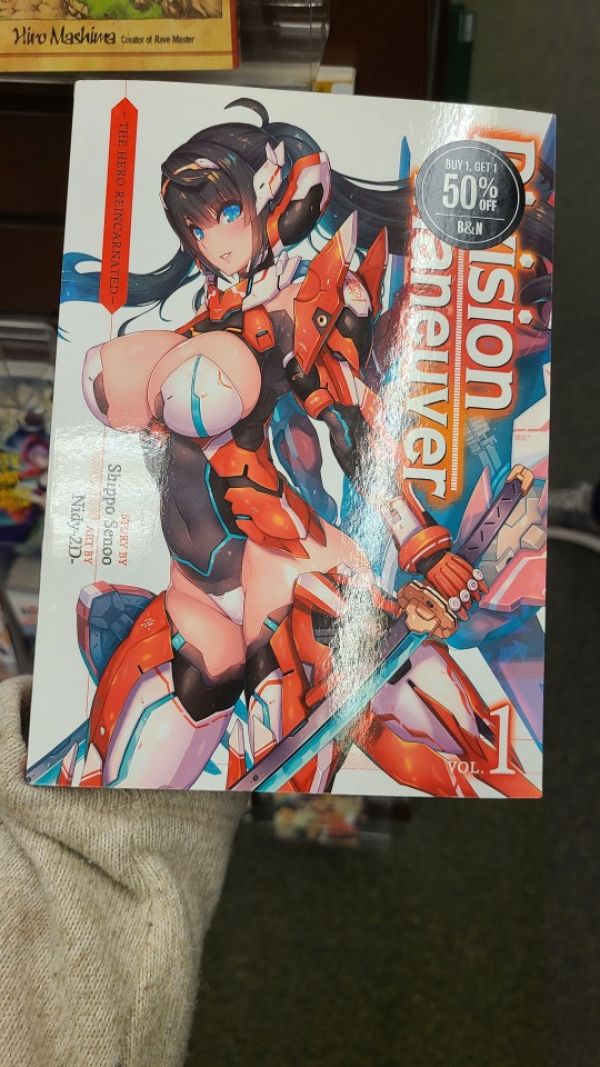 photo of a manga called "Division Maneuver", the cover is a dark haired light skinned anime girl with blue eyes in a red, white, and black mecha suit that covers her arms and legs but leaves her chest open so her breasts are sticking out cupped in white and blue fabric, her crotch is also exposed with a small white triangle of panties covering it